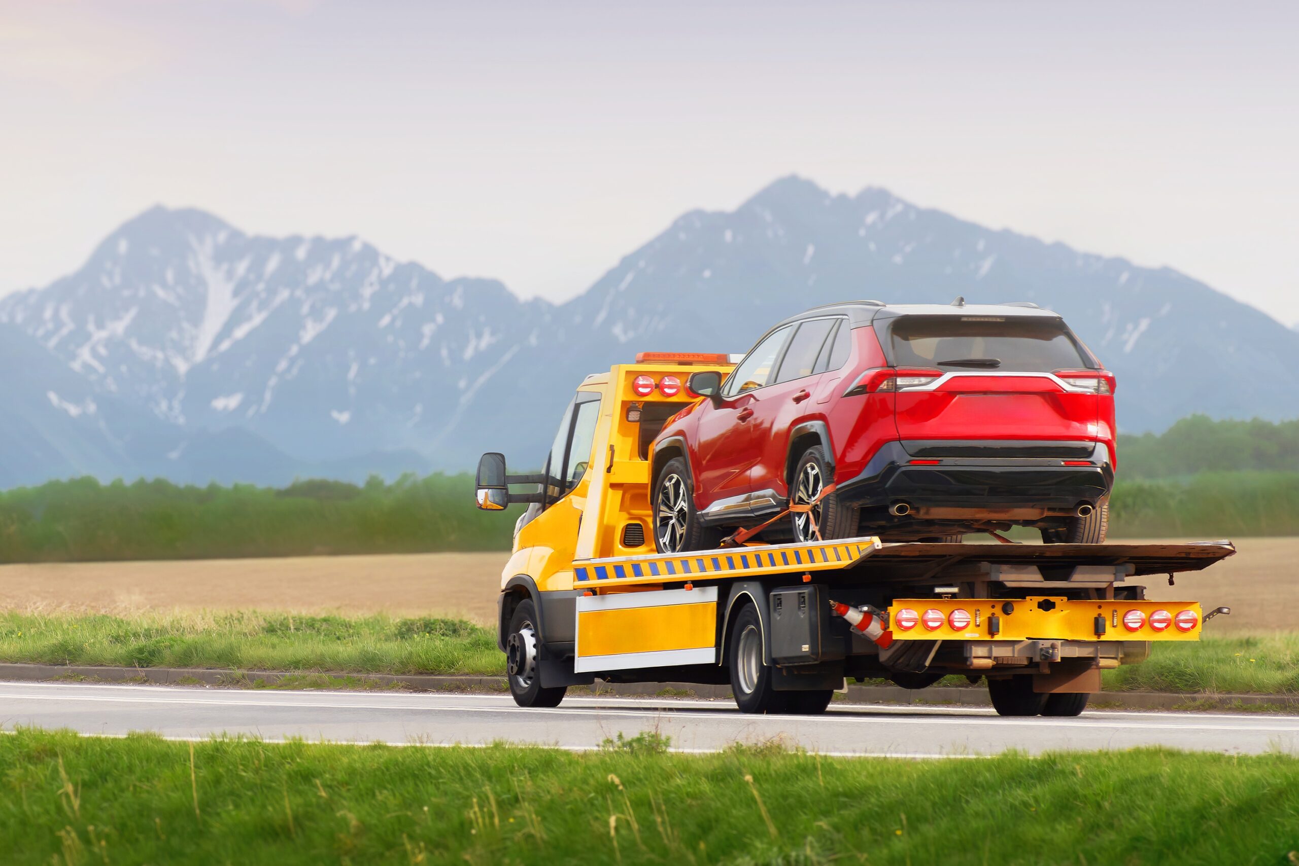 Tow truck hauling car after highway breakdown